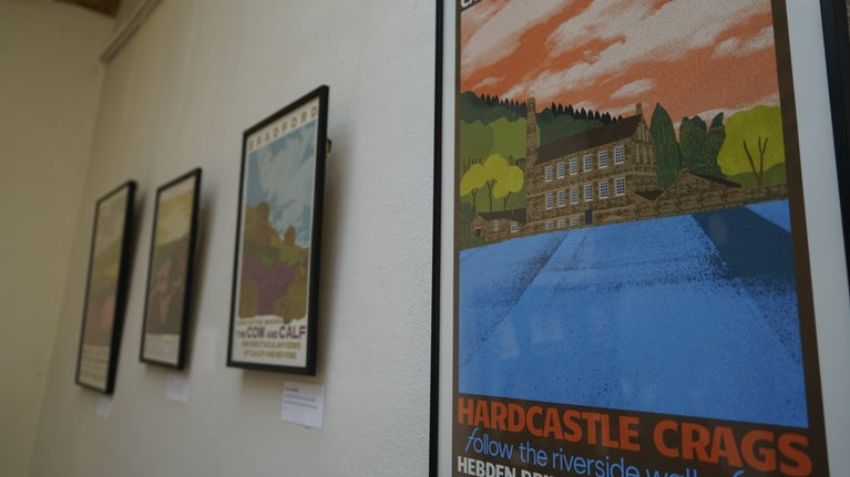 Modern prints of heritage buildings hang on a white wall